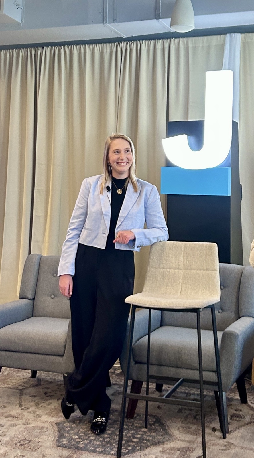 Emily speaking on stage at a tech event